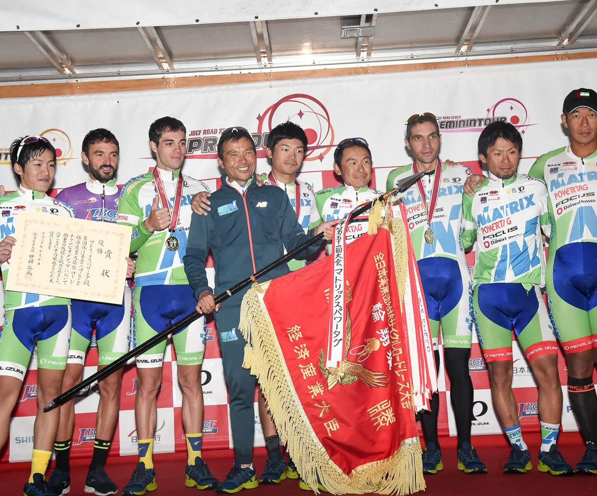 チームメンバーと優勝旗を掲げる集合写真